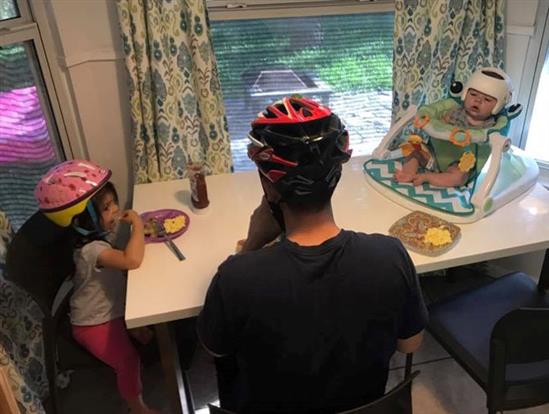 Cả gia đình đội mũ bảo hiểm ăn cơm