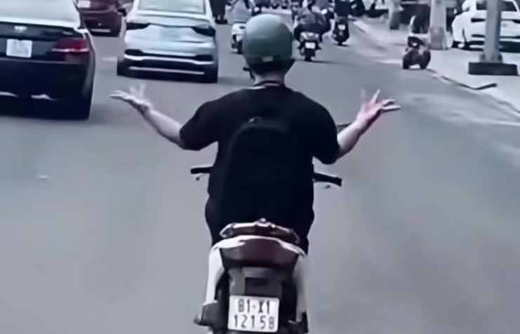 Xác minh người đàn ông bỏ hai tay, múa trên xe máy