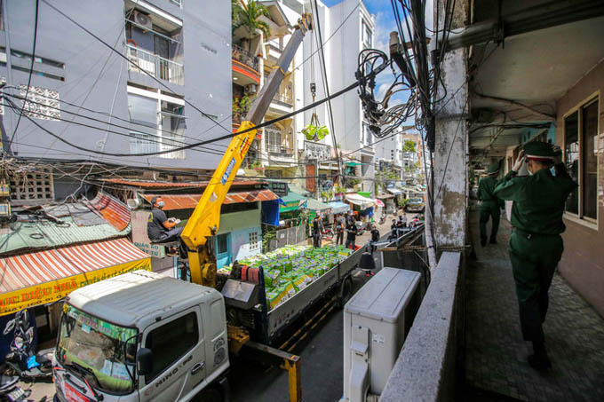 Dùng xe cẩu phát lương thực cho cư dân trong khu cách ly ở TP.HCM
